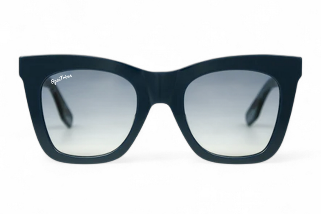 A pair of cat-eye sunglasses with a dark navy blue frame and gradient blue lenses, shown against a plain white background.